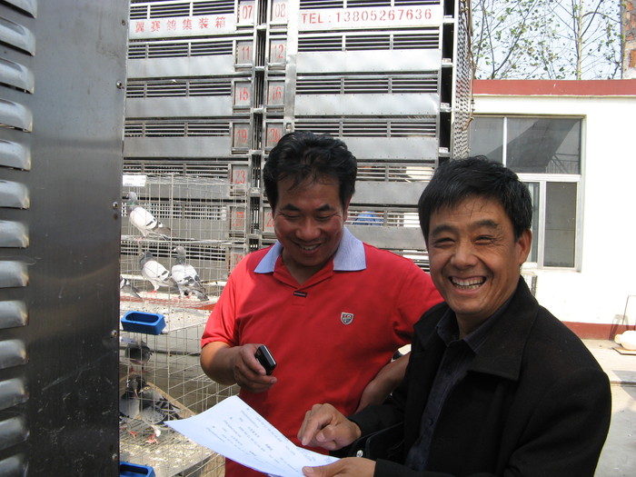 公棚总经理闫运强（左）与鸽友交流